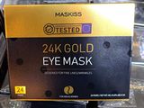 un coffret contenant un masque pour les yeux en or 24 carats posé sur une table