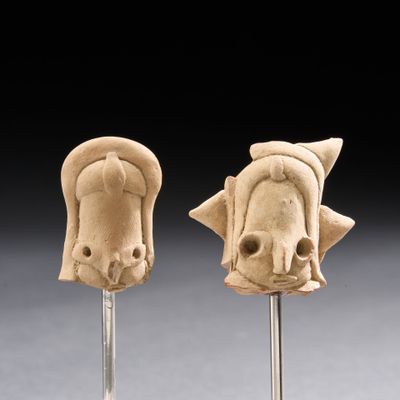 deux petites sculptures d'éléphants sur des tiges, sur fond noir