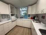 an image of a kitchen with white cabinets and wood flooring