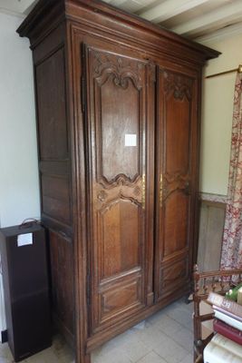 une grande armoire en bois dans le coin d'une pièce