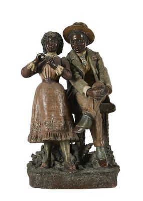 statue représentant un homme et une femme assis sur un banc avec un chien