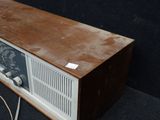 an old radio sitting on a black surface with wires around it