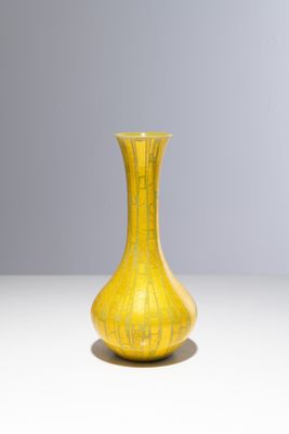 un vase jaune posé sur une table