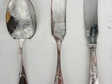 a lot of silver spoons and knives on the table