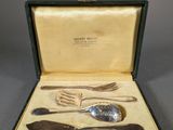 an antique silverware set in a case with a spoon, fork and spoon rest