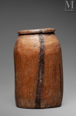 an image of a large wooden jar with a snake skin handle