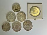 six different british coins sitting in a small box on a table