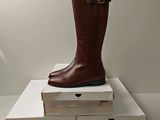 une paire de bottes marron posée sur des cartons