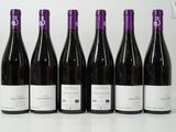 six bottles of wine are lined up on a table