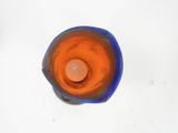 a blue and orange glass candle holder on a white table