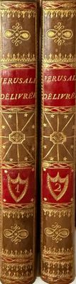 two old books sitting on top of a white table next to each other