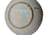 a white plate with a tag on it on a white surface