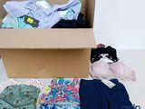 une boîte en carton remplie de vêtements et d'une paire de chaussures
