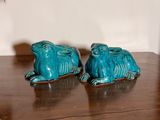 two blue ceramic animals sitting on a wooden table