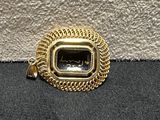 a close up of a gold plated metal object on a black surface