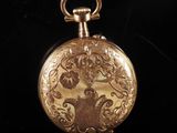 an antique gold pocket watch with a woman ' s face engraved on it