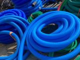 many different colored hoses on the ground next to each other