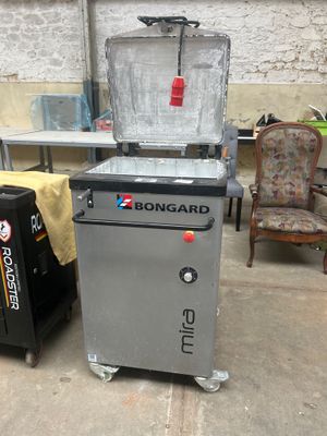 une machine posée par terre à côté d'une poubelle