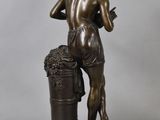 a bronze statue of a man with a bucket of grapes