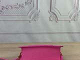 the pink purse is sitting on the table next to the wall