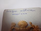 a picture of a gold brooch with a message written on it