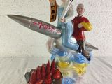 a figurine of a man and a woman on a rocket