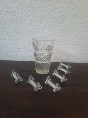 un verre d'eau et cinq morceaux de verre posés sur une table