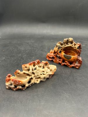 two small shells are sitting on top of a black surface