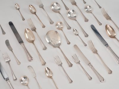 beaucoup d'argenterie sur une table avec des cuillères et des fourchettes