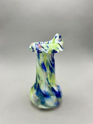 a close up of a glass vase with a blue and green design