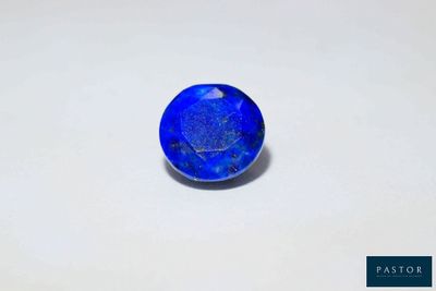 a close up of a blue stone on a white surface