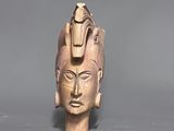 a wooden sculpture of a head with a bird on top of it