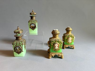 trois flacons de parfum verts et dorés surmontés d'une horloge