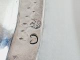 a silver spoon with a silver handle on a white table