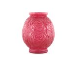 un vase rose posé sur une surface blanche