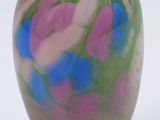 a colorful vase with a lid sitting on a white surface
