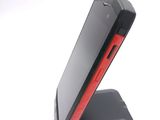 a black and red cell phone sitting on a stand