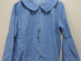 blue denim shirt with peter pan collar on hanger on wall