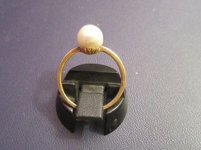 a gold ring with a pearl on top of it