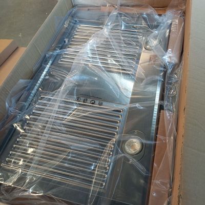 a box with a grill in it that is wrapped in plastic