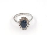 a close up of a ring on a white surface with a blue stone
