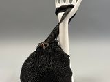 sac orné de perles noires, sur lequel figure une main tenant un couteau et une fourchette