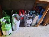 de nombreux types de bouteilles de gaz propane sont disposés sur le sol