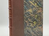 un vieux livre à la couverture marron et à la reliure en cuir marron