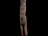 une statue représentant un homme debout sur un bloc de bois