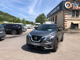 une voiture garée devant un immeuble sur lequel est accrochée une pancarte