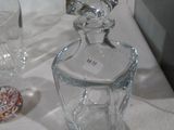 une bouteille en verre et un vase en verre posés sur une table