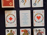 Plusieurs cartes à jouer sont disposées sur une table, à côté d'un paquet de cartes à jouer.
