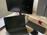 un bureau sur lequel se trouvent un ordinateur portable, un clavier, une souris et un écran