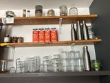 many glasses and jars on the shelves in the kitchen